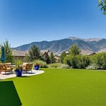 Lush artificial grass lawn in a Colorado backyard with outdoor furniture and mountain backdrop