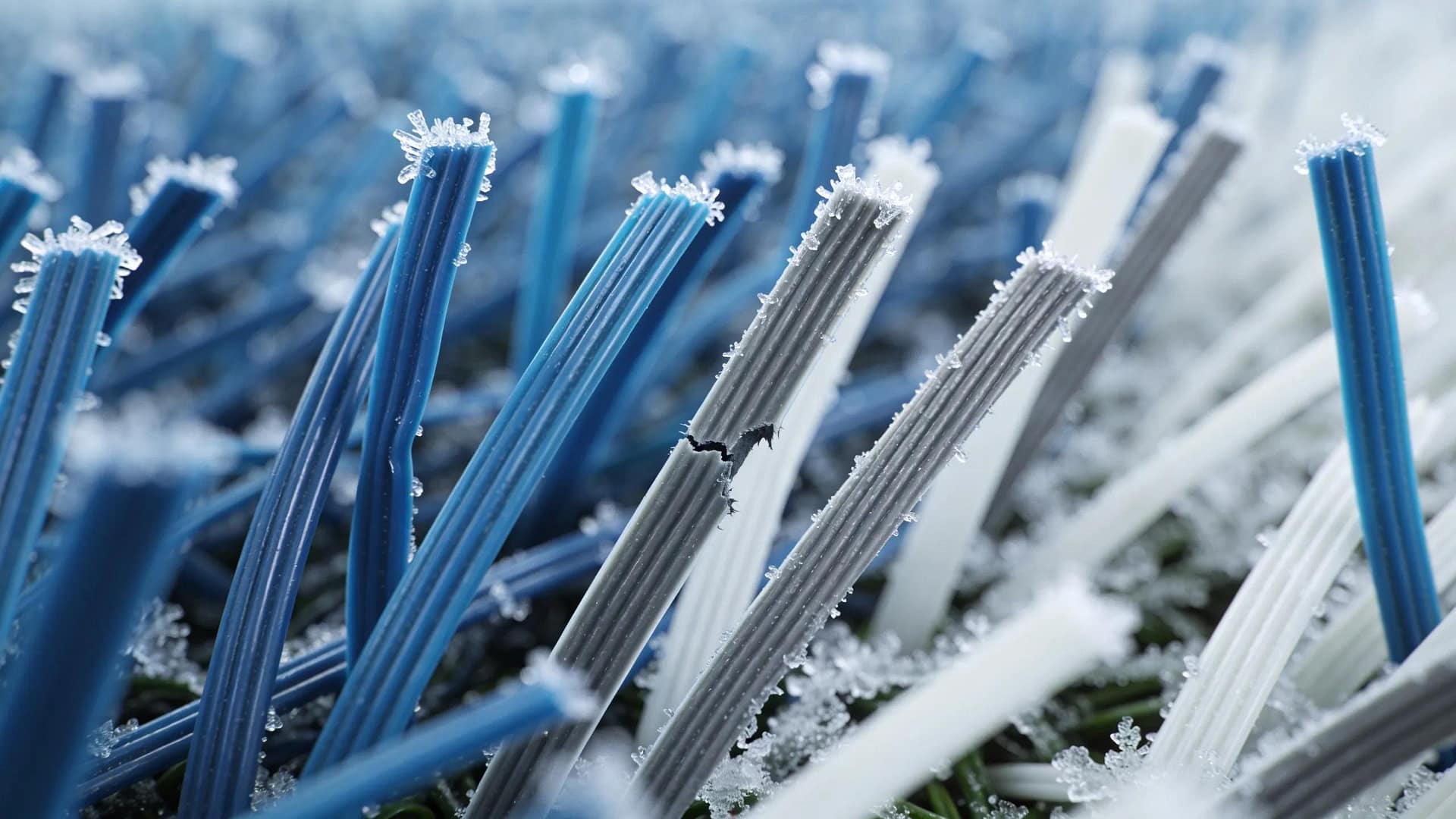 Close-up of synthetic turf fibers showing freeze-thaw impact, focusing on material durability